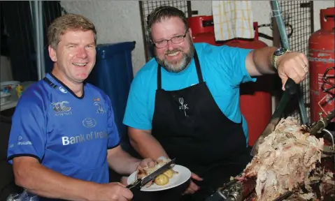  ??  ?? Paul Whelan (right)serving up a feast for Gorey Rugby Club chairman Aidan Wafer at the ‘Pig on a Spit’ night in aid of County Wexford Surf Lifesaving Club at Gorey RFC grounds last Saturday night.