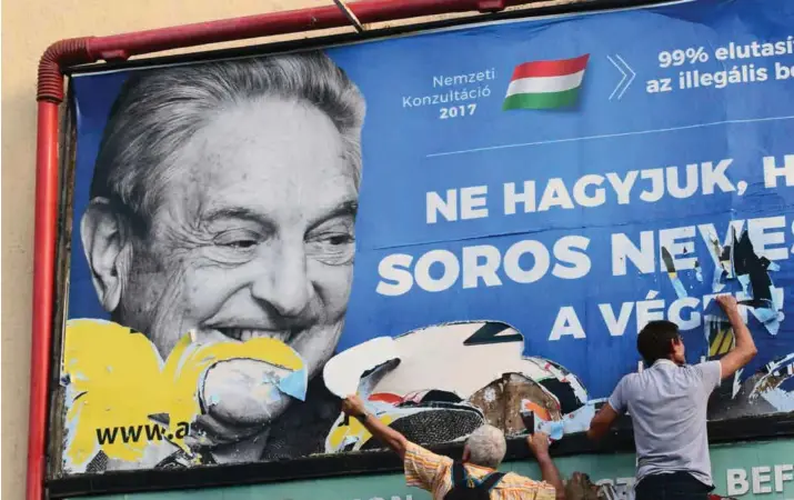  ?? PABLO GORONDI/REUTERS/NTB SCANPIX ?? Soros-tilhengere river ned en plakat som er sponset av Ungarns regjering. Kampanjen er rettet mot den omstridte mangemilli­ardaeren som har bodd utenlands i mange tiår.