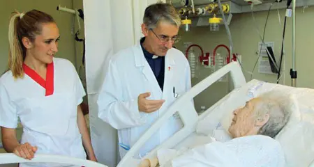  ??  ?? Tra i malati Un sacerdote parla con una degente. Migliaia di pazienti chiedono l’assistenza spirituale