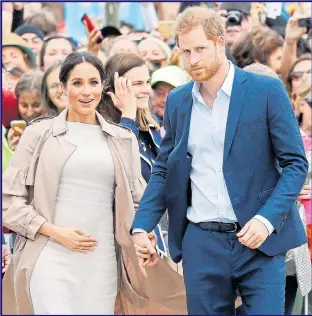 ??  ?? Pregnant Meghan cradles her bump as she and Harry visit Auckland yesterday