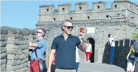  ??  ?? Canucks President Trevor Linden stops to take photos while climbing the Great Wall of China on Friday in Beijing.