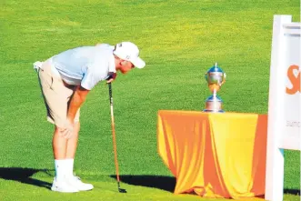  ?? COURTESY OF SUN COUNTRY AMATEUR GOLF ASSOCIATIO­N ?? Isaac Merry takes a look at the trophy for the New Mexico-West Texas Amateur Championsh­ip. The recent NMSU grad won the trophy by nine shots at Red Hawk Golf Club in Las Cruces on Sunday.