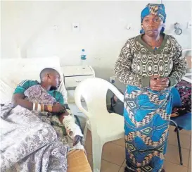  ?? [AP PHOTO] ?? A woman stands near her relative as he receives treatment Monday at the Jos University teaching hospital in Jos, Nigeria, after clashes in central Nigeria between mostly Muslim herders and Christian farmers. Dramatic footage from Jos showed angry...