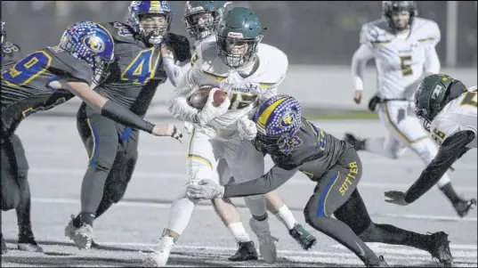  ?? Rich Pedroncell­i The Associated Press ?? Paradise running back Tyler Harrison, center, is tackled by Sutter Union cornerback Roman Resendez in their high school playoff game Saturday in Yuba City, Calif. Paradise had an undefeated season and made it to the section championsh­ip game.