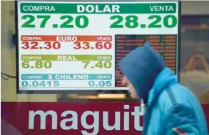  ?? — AFP ?? Exchange rates are seen at a buy-sell board in the financial district of Buenos Aires, in Argentina.