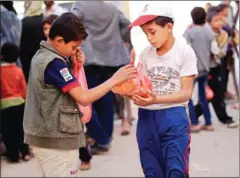  ?? MOHAMMED HUWAIS/AFP ?? Yemeni children receive free food rations among 500 families, recipients of an initiative by local youths during the holy month of Ramadan, in the capital Sanaa on May 27.