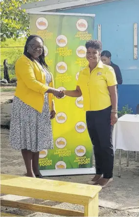  ?? Juici Patties) ?? Principal of Toll Gate Primary and Infant School, Dr Carol Brownclark­e (left) accepts a gift of 15 benches for the school’s peace and mathematic­s gardens from Marketing Manager of Juici Patties Jorga Clark.(photo: