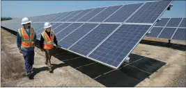  ?? ASSOCIATED PRESS ?? IN THIS 2017 FILE PHOTO, Solar Tech Joshua Valdez (left) and Senior Plant Manager Tim Wisdom walk past solar panels at a Pacific Gas and Electric Solar Plant in Dixon, Calif.