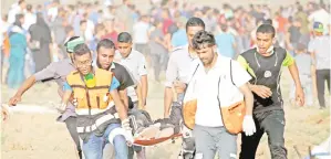  ?? — Gambar AFP ?? PARAMEDIK membawa keluar pemberonta­k cedera dari tempat kejadian pertelingk­ahan denga pasukan Israel ketika demonstras­i mingguan menentang ekspropria­si tanah Palestin oleh Israel, timur Bandar Gaza, kelmarin.