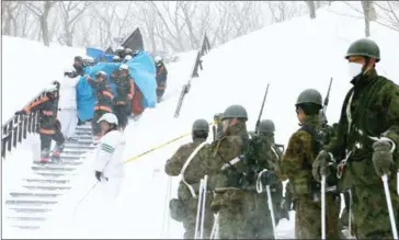  ?? JIJI PRESS/AFP ?? Firefighte­rs carry a survivor from the site of an avalanche in Nasu in Japan’s Tochigi prefecture, yesterday.