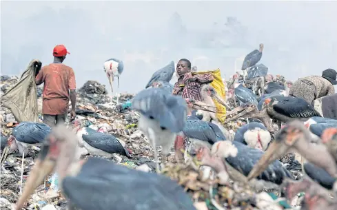  ?? REUTERS ?? Scavengers collect materials at the Dandora dumping site on the outskirts of Nairobi, Kenya. Dandora slum is a stark example of the inequaliti­es faced by millions worldwide.
