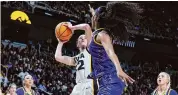  ?? Andy Lyons/Getty Images ?? Iowa’s Caitlin Clark shoots the ball while defended by LSU’s Angel Reese on April 1 in Albany, N.Y.