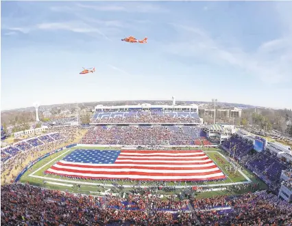  ?? GEOFF BURKE/USA TODAY SPORTS ?? Two Coast Guard helicopter­s fly over before the 2014 Military Bowl between Cincinnati and Virginia Tech in Annapolis.