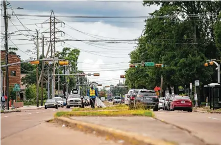  ?? Mark Mulligan / Staff photograph­er ?? A man picks up garbage on the median of Scott Street just north of Wheeler Avenue near the University of Houston. A new report by American Forests finds tree inequity in basically every city, including Houston, grounded in historical redlining policies.