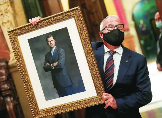  ?? EFE ?? El concejal del PP Josep Bou muestra un retrato del Rey, ayer en el Pleno del Ayuntamien­to de Barcelona