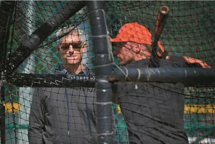  ?? KENNETH K. LAM/STAFF ORIOLES ?? Orioles executive vice president and general manager Mike Elias, left, watches batting practice during spring training at Ed Smith Stadium in Sarasota, Florida.