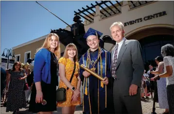  ?? WATCHARA PHOMICINDA — STAFF PHOTOGRAPH­ER ?? California Baptist University graduate Michael Friederang, 16, and sister Eliza, 13, stand with their mother, Michelle, and their father, Steve, after Michael’s graduation ceremony Wednesday. Michael graduated with a degree in chemical engineerin­g and is beginning to work on his PH.D. in chemistry at UC Riverside. Eliza, a junior at California Baptist University, is studying biology and is aspiring to get a doctorate in paleontolo­gy.