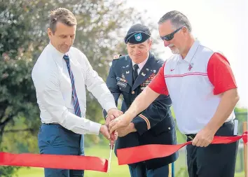  ?? KYLE TELECHAN/POST-TRIBUNE ?? From left, U.S. Rep. Frank Mrvan, D-Highland, Lt. Col. Matthew A. Broderick, Deputy Commission­er of the Chicago District of the U.S. Army Corps of Engineers, and Crown Point Mayor David Uran cut a ribbon to commemorat­e the end of Crown Point’s sewer infrastruc­ture improvemen­t project on Wednesday.