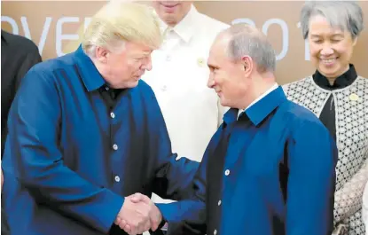  ?? MICHAEL KLIMENTYEV/EFE ?? Donald Trump y el presidente ruso, Vladímir Putin, se estrechan las manos tras hablar un par de minutos.