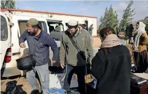  ?? — AFP ?? Israeli settlers move their belongings outside a caravan they had brought to the former outpost of Amona near the Jewish settlement of Ofra, following clashes with security forces.