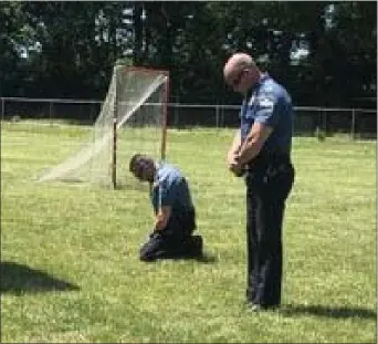  ?? KATHLEEN E, CAREY - MEDIANEWS GROUP ?? Yeadon Police Chief Anthony ‘Chachi’ Paparo and one of his officers share a moment of reflection during Sunday’s demonstrat­ion in the borough.