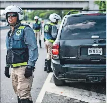  ?? AFP / GETTY IMAGES ?? Caracas. Empleados de ‘Pana’ ayudan a una persona cuyo auto se averió.