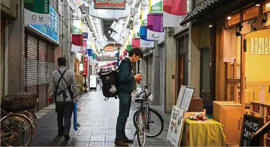  ?? Bloomberg ?? More bite: An Uber Eats delivery courier arrives to pick up meals for a customer at a restaurant. A deal with Postmates will boost the combined companies’ total market share to around 30%. —