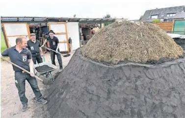  ?? RP-FOTO: KDS ?? Markus Heßelmans, Willi Engelen und Wilhelm Papen (von links) bereiten den Meiler in Reichswald­e vor.