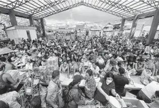  ?? Erwin Mascarinas / Greenpeace via AP ?? Residents affected by the onslaught of Typhoon Rai line up for food in San Juan, Surigao City, in southern Philippine­s. The governor of a central Philippine province pleaded for food and other aid.