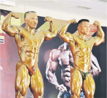  ??  ?? Buda (left) and Wilfred wowing the judges during the bodybuildi­ng’s ‘Champion of Champions’ showdown.