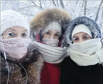  ?? SAKHALIFE RU PHOTO VIA AP ?? In this photo taken on Sunday Anastasia Gruzdeva (left) poses for selfie with her friends as the temperatur­e dropped to about -58 degrees Fahrenheit in Yakutsk, Russia. Temperatur­es in the remote, diamond-rich Russian region of Yakutia have dropped to...