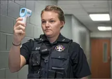  ?? Emily Matthews/Post-Gazette ?? Mt. Lebanon police Officer Hayley Barto holds a thermomete­r up in front of her face on Wednesday at the Mt. Lebanon police station.