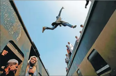  ?? MOHAMMAD PONIR HOSSAIN/ REUTERS ?? A commuter jumps between trains upon arrival at a station to attend the final prayers of Biswa Ijtema, one of the largest Muslim congregati­ons in the world, in Tongi, on the outskirts of the Bangladesh­i capital Dhaka, on Sunday.