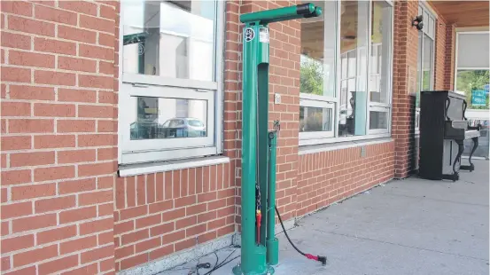  ?? Sam Macdonald ?? The new bike repair stand at the People’s Place Library in downtown Antigonish. According to library staff, many local cyclists are availing themselves of the useful stand set up outside the library on Main Street – one that is ideal for tune-ups or a quick tire pump-up.