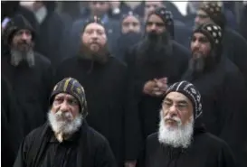  ?? KHALIL HAMRA — THE ASSOCIATED PRESS FILE ?? Clergymen wait for the arrival of Egypt’s Coptic Christian Pope Tawadros II, at the historic al-Muharraq Monastery, a centuries-old site in the province of Assiut, Egypt. Prosecutor­s are investigat­ing the death of a monk at the monastery, who had until recently served in another monastery northwest of Cairo where an abbot was killed in July. Two monks — one of whom has been defrocked — are on trial for the death of the abbot, Bishop Epiphanius. The trial opened Sunday and was scheduled to resume Thursday when the deceased monk was to give his testimony.