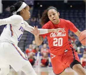  ?? (Photo by Mark Humphrey, AP) ?? Ole Miss guard Madinah Muhammad (20) drives against Florida’s Delicia Washington in the first half of Wednesday’s game at the Southeaste­rn Conference Women’s Tournament in Nashville, Tenn.