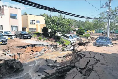  ?? AFP ?? A car is stuck on a road damaged by the earthquake in Sapporo, Hokkaido prefecture, on Thursday. —