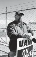  ?? Associated Press file photo ?? General Motors worker Mike Armentrout protests on a picket line outside a transmissi­on plant in Toledo, Ohio. GM and the UAW have made progress negotiatin­g on key issues including the use of temporary workers and the path those members will have to reach full-time status.