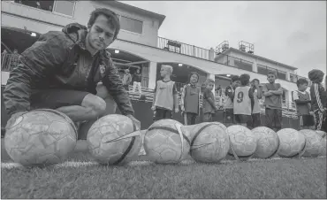  ?? Photo by The Washington Post ?? Guillermo Escudero (left) prepares to work with a small group of kids during open tryouts for FC Barcelona's soccer school in Northern Virginia, which will open this fall with enrollment