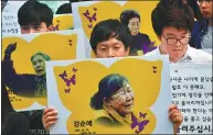  ?? JUNG YEON-JE / AFP ?? Protesters hold placards showing portraits of former comfort women during a rally in Seoul on Thursday.