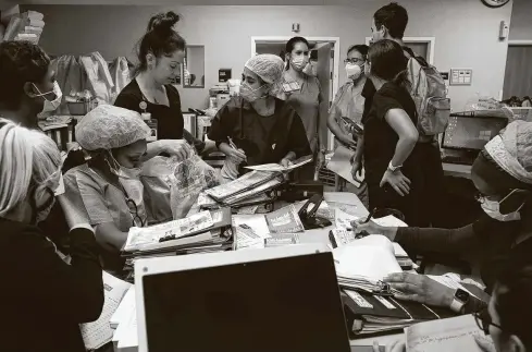  ?? Photos by Godofredo A. Vásquez / Staff photograph­er ?? Nurses update one another on patients’ statuses during a shift change in the COVID-19 intensive care unit at United Memorial Medical Center.