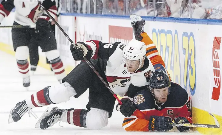  ?? JASON FRANSON/THE CANADIAN PRESS ?? Arizona’s Christian Fischer takes down Connor McDavid Thursday at Rogers Place. McDavid had the last laugh with two goals in a 3-2 Oilers OT win.