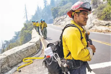  ?? Photos by Santiago Mejia / The Chronicle ?? San Diego firefighte­r Juan Mendez pauses to listen to radio calls during the Ferguson Fire near Tunnel View in Yosemite National Park. In areas where past fires had cleared fuel, the fire has tapered off.