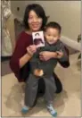  ?? CHINA AID— THE ASSOCIATED PRESS ?? In this photo taken early Dec 27, 2017 and released by China Aid, Li Aijie and her son Li Mutian pose with a photo of her husband Zhang Haitao, one of two photos she has after authoritie­s confiscate her electronic devices, upon arriving in the U.S. in...