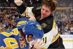  ?? Jeffrey T. Barnes / Associated Press ?? Boston’s Trent Frederic, right, and Buffalo’s Dylan Cozens fight in the second period of the Bruins’ 7-0 win Sunday in Buffalo.