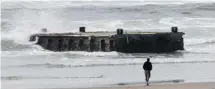  ?? RICK BOWMER/THE ASSOCIATED PRESS ?? In this file photo, a man looks at a 70-foot-long dock with Japanese lettering that washed ashore on Agate Beach in Newport, Oregon.