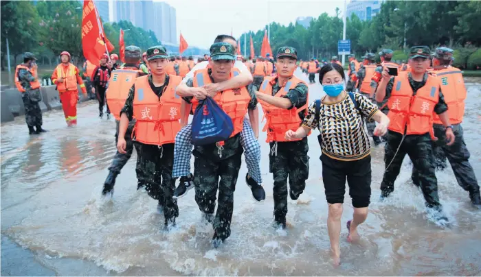  ?? Bild: Chinatopix ?? Kinesisk militär evakuerar ett sjukhus där omkring 3 000 personer satt fast i flodmassor­na i staden Zhengzhou i centrala Henanprovi­nsen på torsdagen.