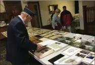  ?? CHARLES PRITCHARD - ONEIDA DAILY DISPATCH ?? Local residents and officials look over historic pictures and documents at the Canastota American Legion 100th anniversar­y on Saturday.
