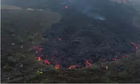  ??  ?? People stand on the edge of slowly moving lava coming from the Pacaya volcano near El Patrocinio village. Photograph: Moisés Castillo/AP