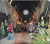  ??  ?? The kirk was filled with Christmas trees.